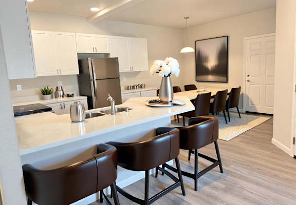 A kitchen with brown chairs and a white counter.