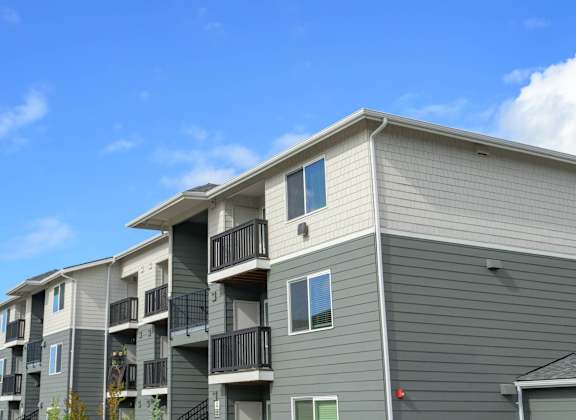 Apartment building with balconies and a clear blue sky.