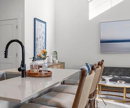 A modern kitchen with a large island and a fridge.