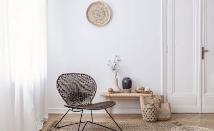 NEW ALT TEXT a living room with a wicker chair and a small table