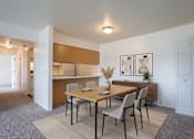 Thumbnail 9 of 11 - A dining room with a wooden table and chairs.