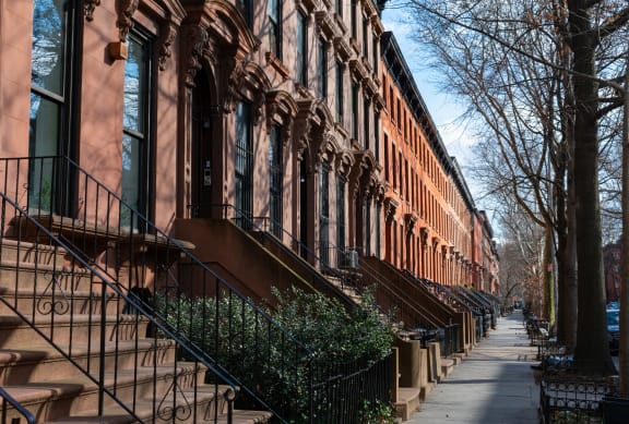 a row of red brick apartment buildings on a sidewalk
