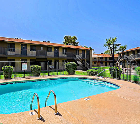 A swimming pool in front of apartment buildings.
