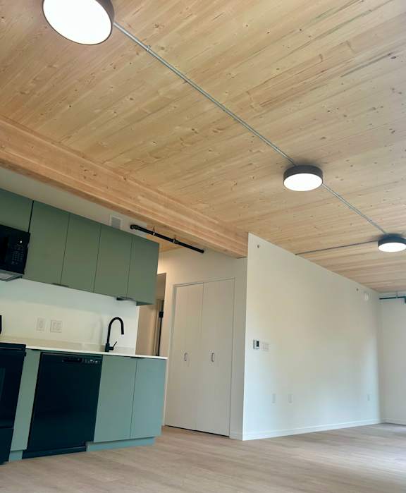 A room with a wooden ceiling and a white wall.