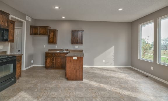 an empty kitchen with an island in the middle of it