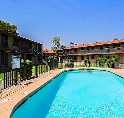 A swimming pool in front of apartment buildings.