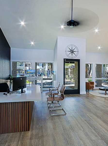 A reception area for Northernly Apartments with a white reception desk and chairs.