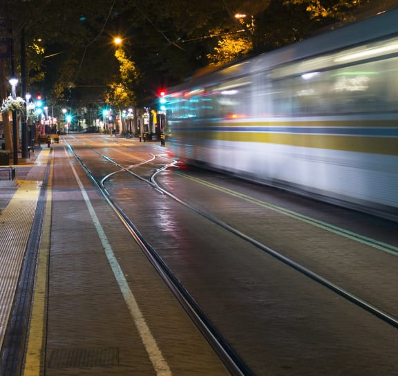 Train speeding down a street at night at Rush River Apartments, California