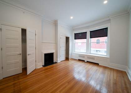 A room with a fireplace and a window with blinds.