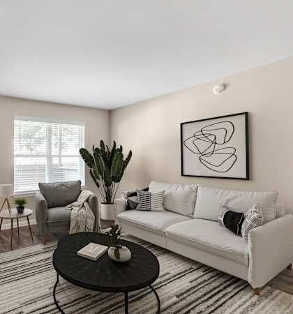 A living room with a white couch, a black coffee table, and a large painting on the wall.