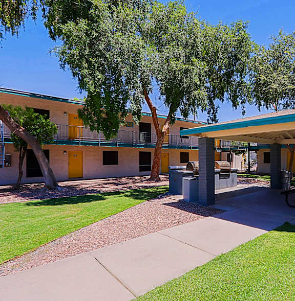 A building with a yellow door and a green lawn in front.