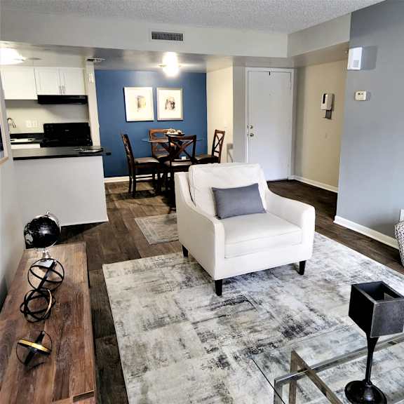 an open concept living room and dining area with a white dining table and rattan chairs at Laurel Oaks Apartments, Florida, 33637