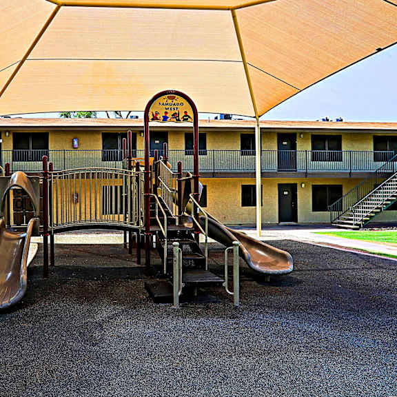 A playground with slides and a canopy.