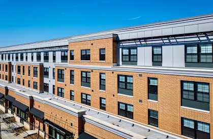 A multi-story building with a mix of brick and white exterior walls.