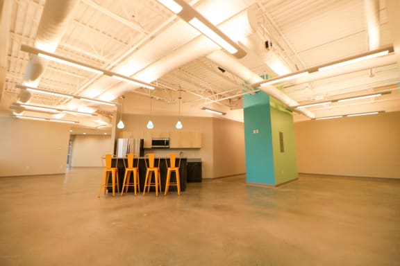 a large room with chairs and a kitchen in it
