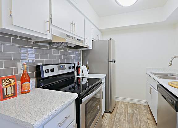 a kitchen with stainless steel appliances and white cabinets and a counter top at Spring Meadow Apartments, Glendale, AZ, 85302