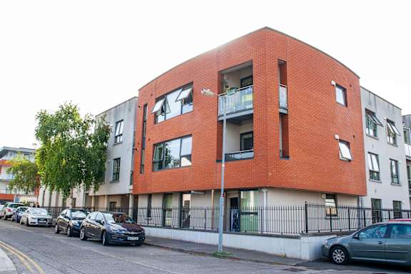 an apartment building on a city street with parked cars