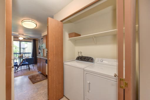 In Unit Washer and Dryer, Wood Cabinets, Shelves and View of Dining Room