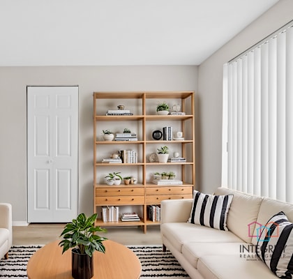 A living room with a white couch, a wooden coffee table, and a white door.