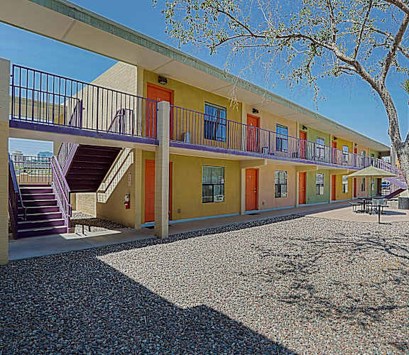 A row of colorful houses with a tree in front.