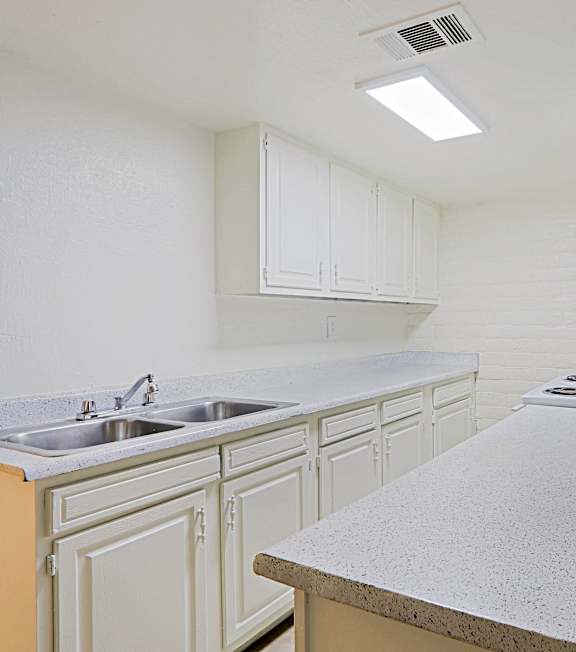 A kitchen with white cabinets and a granite countertop.