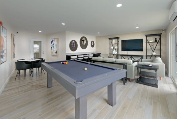 a games room with a blue pool table in the middle of a room