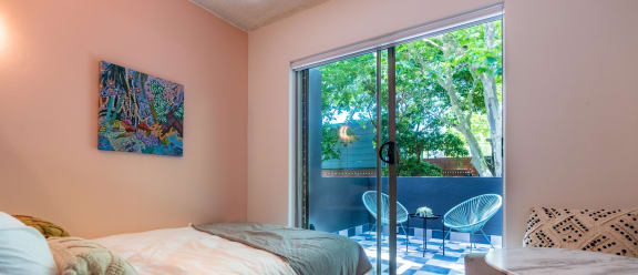 a bedroom with a bed and a door to a patio
