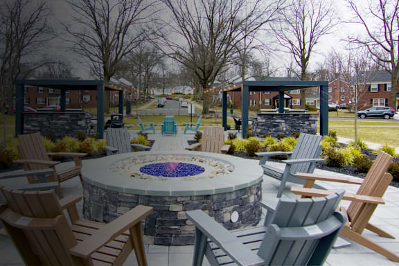 A stone fire pit is surrounded by chairs in a park. at Alister Morristown, Morristown, NJ, 07960