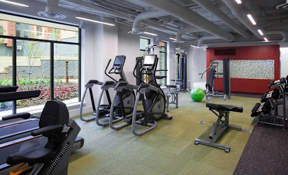 A gym with treadmills, exercise bikes, and other equipment at The Atrium, Washington, DC, 20019