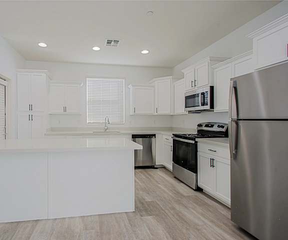 an empty kitchen with white cabinets and stainless steel appliances