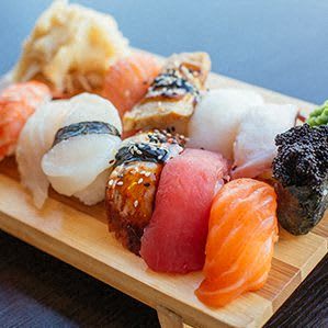 a wooden cutting board with sushi on it