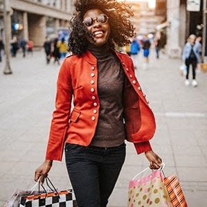 a woman walking down the street with shopping bags