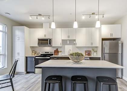 A modern kitchen with a large island and bar stools.