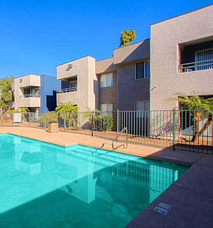 A swimming pool in front of apartment buildings.