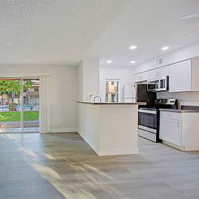 A kitchen with white cabinets and a microwave on top of the counter.