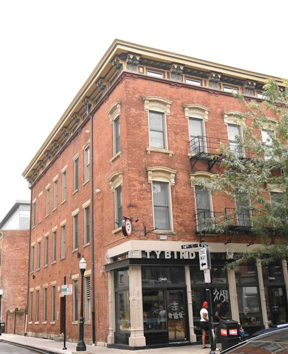 a building on the corner of a street with cars parked in front of it