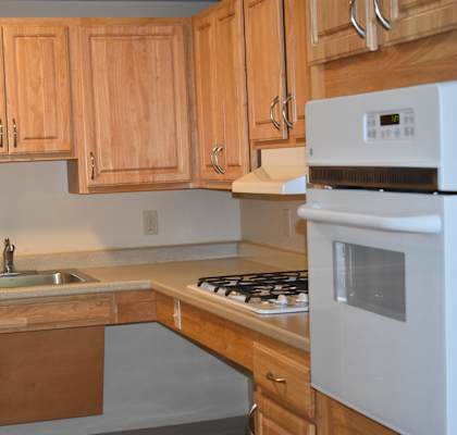 a kitchen with wooden cabinets and a stove and sink
