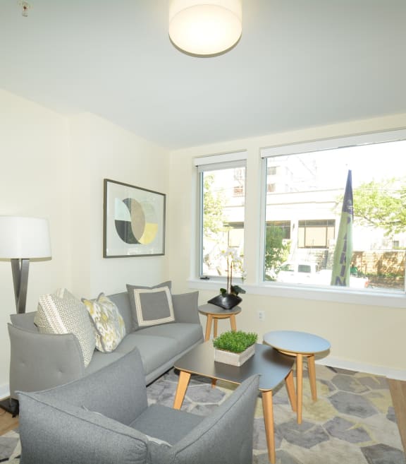 a living room with white walls and a large window