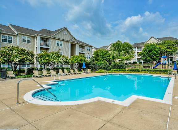 A large swimming pool in front of apartment buildings.