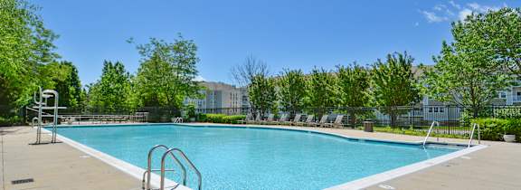 A large swimming pool in front of apartment buildings.
