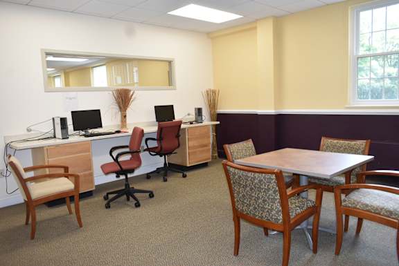 a conference room with desks and chairs and a table