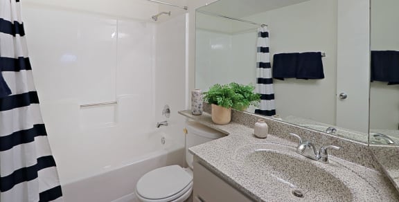 a bathroom with a white bathtub and a black and white shower curtain