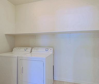 an empty laundry room with a washer and dryer in it