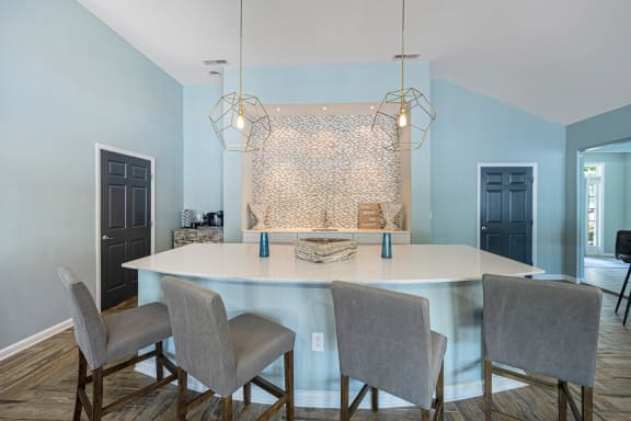 a kitchen with blue walls and a white island and chairs