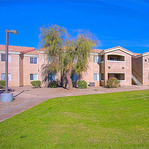 Apartment complex with a green lawn in front.