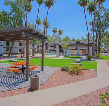 a park with picnic tables and a grill
