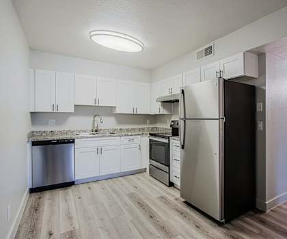 a kitchen with white cabinets and stainless steel appliances