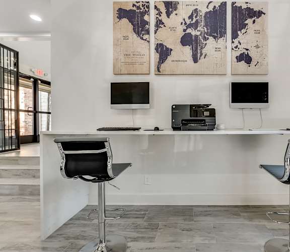 a desk with two computer monitors and two chairs