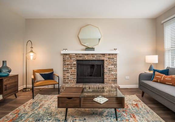 a living room with a brick fireplace and a coffee table