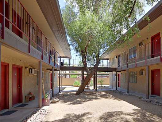 a courtyard with trees and red doors